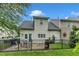 Home's back exterior features a patio, black fence, lush green lawn, and a sun decoration at 8611 London Park Ct, Raleigh, NC 27615