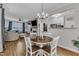 Open-concept dining area connecting to living room, featuring a dining table and a modern light fixture at 8611 London Park Ct, Raleigh, NC 27615