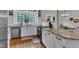 Well-lit kitchen with stainless steel appliances, a large window, granite countertops, and white cabinets at 8611 London Park Ct, Raleigh, NC 27615