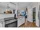 Open kitchen with modern appliances, white cabinets, granite countertops, and hardwood floors at 8611 London Park Ct, Raleigh, NC 27615