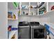 Organized laundry room with shelving and modern washer and dryer at 8611 London Park Ct, Raleigh, NC 27615