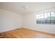 Empty bedroom features hardwood floors, neutral walls and a large window at 1002 Willow Drive Dr # 37, Chapel Hill, NC 27514