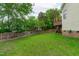 View of the backyard and the exterior of the house with a deck, lawn, and trees at 1004 Manderston Ln, Apex, NC 27502