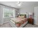 Cozy bedroom featuring a queen-sized bed, natural light, and a ceiling fan at 1004 Manderston Ln, Apex, NC 27502