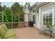 View of the wooden deck with a grill, chair, and a green cushioned sofa against the exterior of the home at 1004 Manderston Ln, Apex, NC 27502