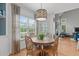 Breakfast nook features a round wooden table, four chairs, decorative lighting, and views of the backyard at 1004 Manderston Ln, Apex, NC 27502