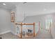 Upstairs landing features carpeted floors, wood railing, and a view of the living room at 1004 Manderston Ln, Apex, NC 27502