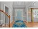 Welcoming foyer with hardwood floors, a patterned rug, a decorative front door, and a staircase at 1004 Manderston Ln, Apex, NC 27502