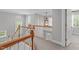 Bright hallway featuring a wooden banister, decorative windows, and an elegant chandelier at 1004 Manderston Ln, Apex, NC 27502
