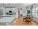 Bright eat-in kitchen features stainless steel appliances, a blue island, and a breakfast nook with unique lighting at 1004 Manderston Ln, Apex, NC 27502