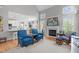 Cozy living room with a fireplace, vaulted ceiling, large windows, and open access to the breakfast bar and dining room at 1004 Manderston Ln, Apex, NC 27502