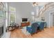 Bright living room featuring a fireplace, a staircase, many windows, and comfortable seating at 1004 Manderston Ln, Apex, NC 27502