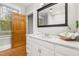 Bright bathroom featuring a marble countertop, wood floors, and a framed mirror at 1008 Dorothea Dr, Raleigh, NC 27603