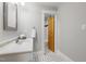 Well lit bathroom featuring patterned tile floor, a white basin sink, and doorway view to shower at 1008 Dorothea Dr, Raleigh, NC 27603