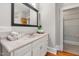 Bathroom vanity with white cabinets, decorative mirror, and neutral countertops at 1008 Dorothea Dr, Raleigh, NC 27603