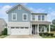 Charming two-story home featuring blue siding, white trim, and a welcoming front porch with rocking chairs at 102 Michelangelo Pl, Morrisville, NC 27560