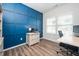Bright office space with custom blue wall trim, wood floors, desk, and natural light from the large windows at 102 Michelangelo Pl, Morrisville, NC 27560