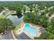 Aerial view of the community pool and lake with a fountain surrounded by greenery at 103 Lake Tillery Dr, Cary, NC 27519