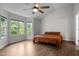 Spacious bedroom with large windows, ceiling fan, and wood-look flooring at 103 Lake Tillery Dr, Cary, NC 27519
