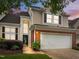 Charming two-story home featuring a two-car garage, brick accents, and manicured landscaping at 103 Lake Tillery Dr, Cary, NC 27519