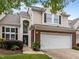 Two-story home with attached garage, brick accents, and manicured landscaping at 103 Lake Tillery Dr, Cary, NC 27519