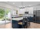 Open concept kitchen with an island, stylish barstools, and stainless steel refrigerator at 103 Lake Tillery Dr, Cary, NC 27519
