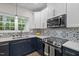 Updated kitchen featuring white and blue cabinetry, quartz countertops, and modern appliances at 103 Lake Tillery Dr, Cary, NC 27519