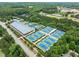 Aerial view of community tennis courts featuring multiple courts, trees, and clubhouse for recreational enjoyment at 103 Lake Tillery Dr, Cary, NC 27519