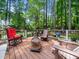 Inviting back deck with a fire pit and comfortable seating, surrounded by lush trees at 103 Lochwood West Dr, Cary, NC 27518