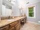 Bathroom featuring double sinks with granite countertops, a window, and tile flooring at 103 Lochwood West Dr, Cary, NC 27518