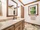 Bathroom featuring a granite countertop, custom cabinets, and a framed mirror at 103 Lochwood West Dr, Cary, NC 27518