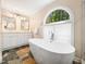 Bathroom with a modern free-standing tub, double sinks, and decorative window at 103 Lochwood West Dr, Cary, NC 27518