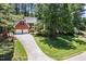 Beautiful brick house with an extended driveway surrounded by mature trees and landscaping at 103 Lochwood West Dr, Cary, NC 27518