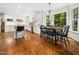 Bright kitchen and breakfast area features white cabinetry, stainless appliances, and large windows with backyard views at 103 Lochwood West Dr, Cary, NC 27518