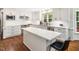 Bright kitchen features white cabinetry, stainless appliances, island with quartz countertop, and subway tile backsplash at 103 Lochwood West Dr, Cary, NC 27518