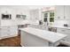 Bright kitchen features white cabinetry, stainless appliances, island with quartz countertop, and subway tile backsplash at 103 Lochwood West Dr, Cary, NC 27518