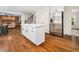 Bright kitchen island features white cabinetry, quartz countertop, and hardwood floors leading to the kitchen at 103 Lochwood West Dr, Cary, NC 27518