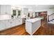 Bright kitchen features white cabinetry, stainless appliances, island with quartz countertop, and hardwood floors at 103 Lochwood West Dr, Cary, NC 27518