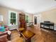 Sunlit living room featuring hardwood floors, a piano, and classic furnishings at 103 Lochwood West Dr, Cary, NC 27518