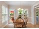 Sun-drenched breakfast nook showcases a wooden table set, surrounded by large windows and a back door at 103 Rose Sky Ct, Cary, NC 27513