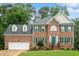 Traditional brick home with green shutters, manicured landscaping, and an attached two-car garage at 103 Rose Sky Ct, Cary, NC 27513