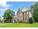 Beautiful brick home with lush lawn, mature trees, and a welcoming green front door at 103 Rose Sky Ct, Cary, NC 27513