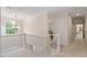 Upstairs hallway with natural lighting from a large window, white railings and carpeted floors at 103 Rose Sky Ct, Cary, NC 27513