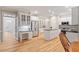 Spacious kitchen showcases a central island, stainless appliances, white cabinetry, and hardwood floors at 103 Rose Sky Ct, Cary, NC 27513