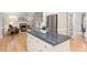 Contemporary kitchen features an island with dark countertops and stainless appliances, flowing into the living area at 103 Rose Sky Ct, Cary, NC 27513