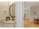 Half-bathroom featuring granite countertop, octagon mirror and hardwood floors at 103 Rose Sky Ct, Cary, NC 27513
