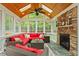 Bright sunroom features a stone fireplace, wood-paneled ceiling, skylights, and comfortable outdoor seating at 103 Rose Sky Ct, Cary, NC 27513