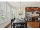 Bright dining room with hardwood floors, modern lighting, and a large window with plantation shutters at 10529 Sablewood Dr # 111, Raleigh, NC 27617