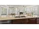 A spacious kitchen island with granite countertop sits next to a fireplace and ample natural lighting at 10529 Sablewood Dr # 111, Raleigh, NC 27617