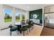 Elegant dining room features a modern table, green accent wall, and bright windows overlooking a lush landscape at 10538 Pleasant Branch Dr # 28, Raleigh, NC 27614